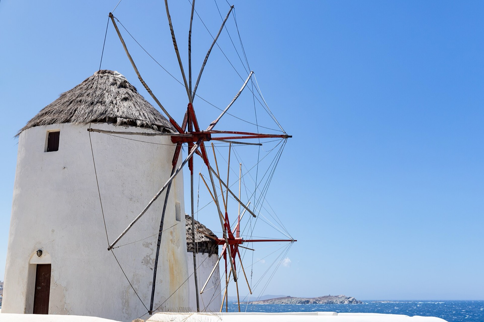 Wooden sails of the Kato Mili windmills against a blue sky